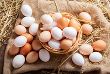 Basket Of Colorful Fresh Eggs On Wooden Table