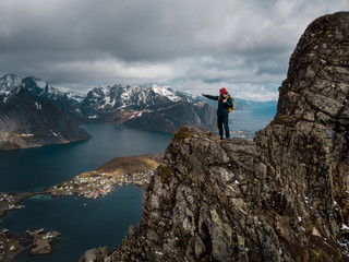 Fototapete - Man traveler hiking on Reinebringen mountain ridge in Norway lifestyle adventure traveling