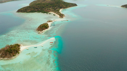 aerial seascape island with white beach. Bulog Dos, Philippines, Palawan. tourist boats on coast tropical island. Seascape bay with turquoise water and coral reef.