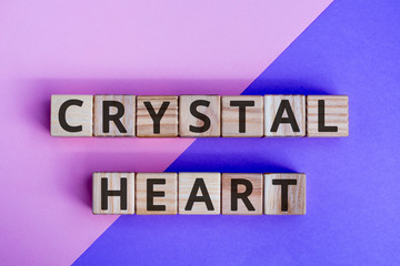 Fototapete - phrase crystal heart, wooden cubes with letters on color background top view