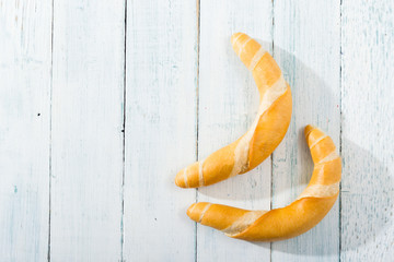 Wall Mural - crescent rolls on white wooden table, directly above