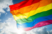 Close-up Of Gay Pride Rainbow Flag Fluttering Backlit In Bright Sunny Sky
