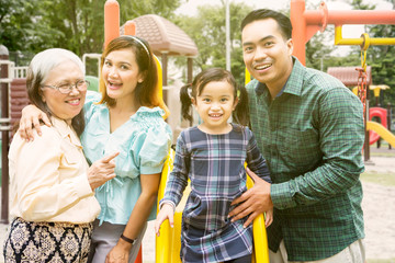 Wall Mural - Three generation family looks happy in playground