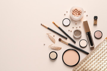 cosmetic bag and different luxury makeup products on color background, flat lay. space for text