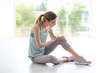 © New Africa - Woman in sportswear suffering from knee pain at gym