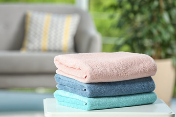 Canvas Print - Stack of folded clean soft towels on table indoors. Space for text