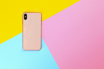 Modern smartphone on colorful background, top view. Space for text