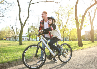 Poster - Father teaching his son to ride bicycle outdoors