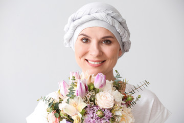 Sticker - Woman after chemotherapy with bouquet of flowers on light background