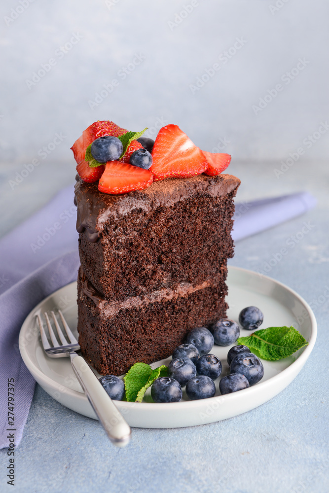 Plate with piece of tasty chocolate cake on table