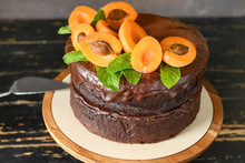 Stand With Tasty Chocolate Cake On Wooden Table
