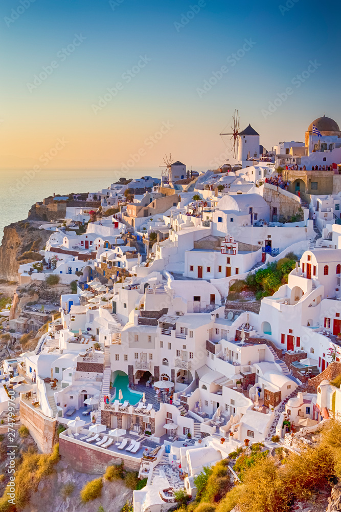 Cityscape of Oia Village in Santorini Island Located on Red Volcanic Caldera Before Sunset. - obrazy, fototapety, plakaty 