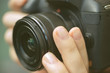 © aldarinho - Photographer hands holding a digital camera, focusing and taking photos, macro closeup