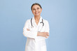 © shurkin_son - Horizontal image of happy successful mature gray haired female pediatrician posing at blue wall, keeping arms on her chest. People, age, healthcare jobs, occupations and medical careers concept