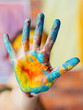 © golubovy - Modern fine art performance. Closeup of hand dirty with blue and yellow paint. Blur background.