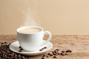 coffee cup on old wooden table with cream wall background.