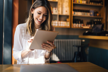 Wall Mural - Beautiful brunette woman using laptop in cafe