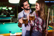 © NDABCREATIVITY - Couple drinking beer and playing snooker on date