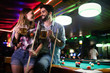 © NDABCREATIVITY - Happy young man playing snooker with his girlfriend. Happy loving couple.