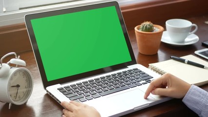 4K. close-up woman working with laptop computer, using finger with keyboard and touchpad or trackpad for slide. computer laptop with blank green screen chroma key.