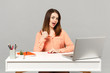 © ViDi Studio - Young confident woman in pastel casual clothes showing thumb up sit, work at white desk with pc laptop isolated on gray background. Achievement business career lifestyle concept. Mock up copy space.