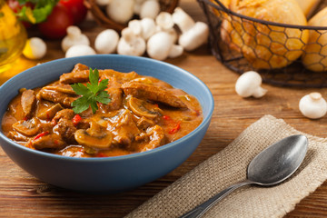 Boeuf, Stroganow, Strogonow. Classic, Russian beef stew.  Served in a blue bowl. Front view. Natural background.