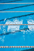 Water Surface In The Sports Swimming Pool. Blue Water And Swim Lane Dividers. Sports And Health Concept.