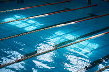 Water Surface In The Sports Swimming Pool. Blue Water And Swim Lane Dividers. Sports And Health Concept.