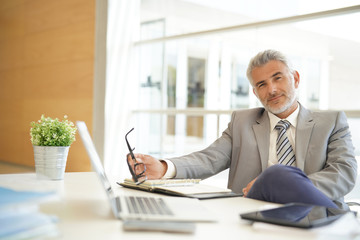 Wall Mural - Mature businessman sitting casually at desk