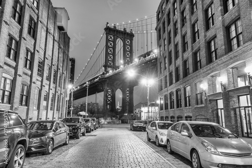 Cuadros en Lienzo Night view of the Empire State Building through the pylons of Manhattan Bridge