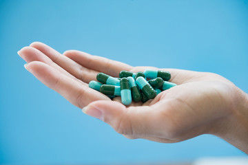 Woman's hand pours the medicine pills out of the bottle