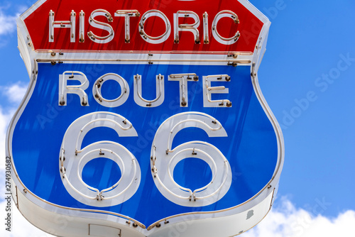 Red, white and blue neon sign on the famous, historic Route 66 in front of blue Wallpaper Mural