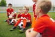 © matimix - Happy kids in school sports team. Boys gathering and having fun on sports field. Cheerful children boys players of school soccer team. Happy boys in junior football team