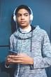 © Oleksandr - Afro-American young man listening to music with headphones. Teenager mixed race black.