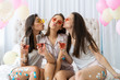 © opolja - Pajama party. Attractive young smiling women in pajamas drinking champagne while having a slumber party in the bedroom.