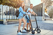 © Fxquadro - Young attractive couple is enjoying nice summer day while riding their own electro scooters.