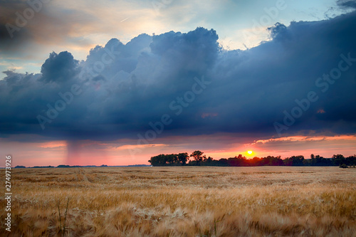 Foto  Beautiful sunset and storm clouds over the fields, on the last day of spring, in Biskupice Podgorne near Wroclaw, Poland