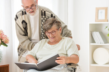 Poster - Happy Senior married couple with photo album at nursing home