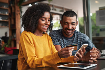 Canvas Print - Man looking at his girlfriend shopping online in cafe