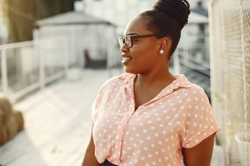 Black girl. Woman in apink blouse. Lady in a glasses