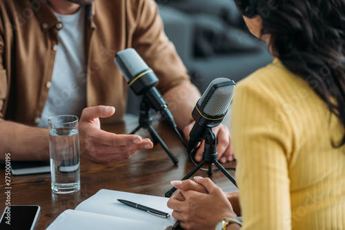Fotomural cropped view of two radio hosts recording podcast in broadcasting studio
