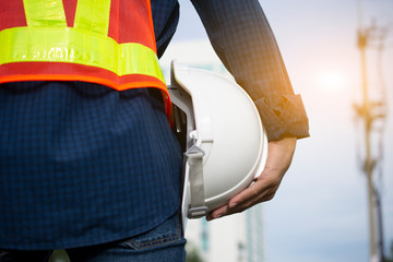 Engineering holds white safety hats and electric pole background