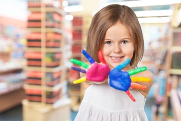 Wall Mural - Little girl showing painted hands on bright background