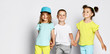 © FAB.1 - Studio portrait of children on a light background: full body shot of three children in bright clothes, two girls and one boy. Triplets, brother and sisters.