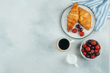 Wall Mural - Food background. Coffee, croissants and berries for breakfast on light concrete background. Top view with copy space