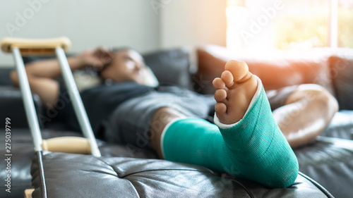 Bone fracture foot and leg on male patient with splint cast and crutches during Tableau sur Toile