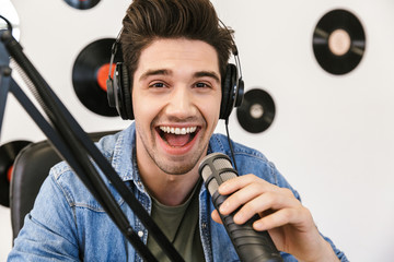 Wall Mural - Cheerful young man radio host broadcasting