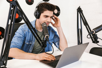 Wall Mural - Cheerful young man radio host broadcasting