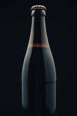 Aufkleber - Close up Glass brown Bottle of beer on a black background behaid.