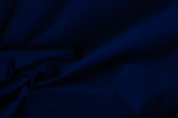 Velvet matte texture, dark blue corduroy fabric background close-up.